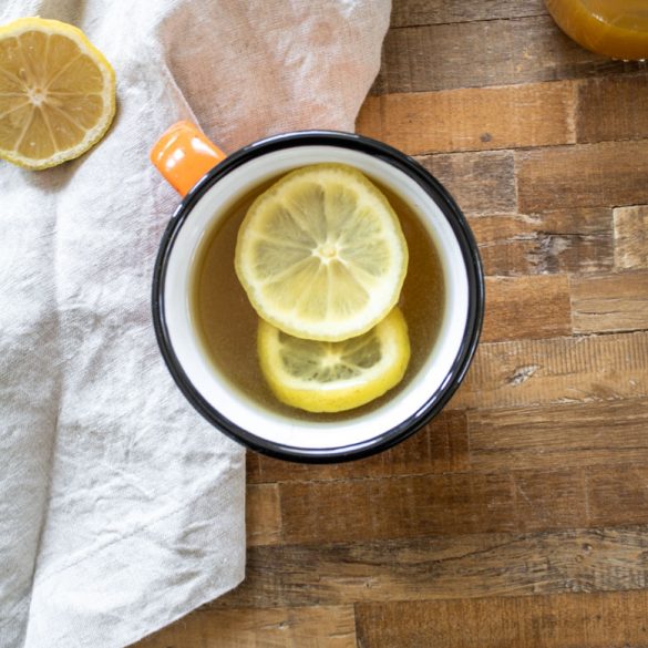 a ginger turmeric honey hot toddy in a big mug on a wood coffee table