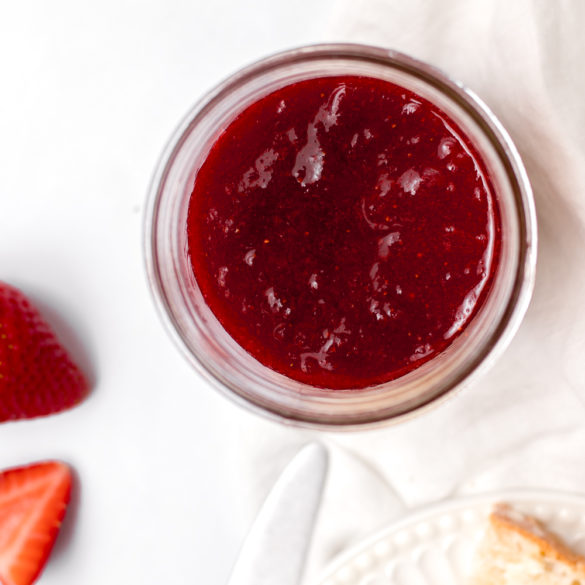 fresh strawberry jam sitting next to slices of toast