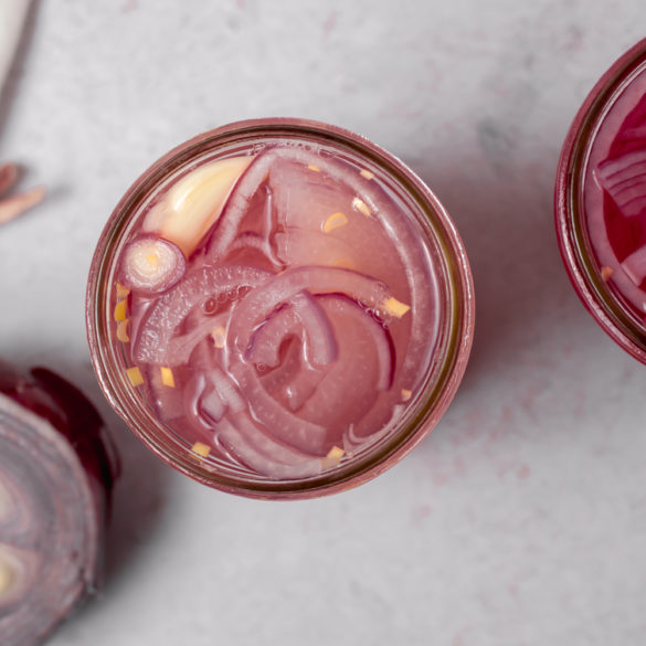 red onions pickling in a mason jar