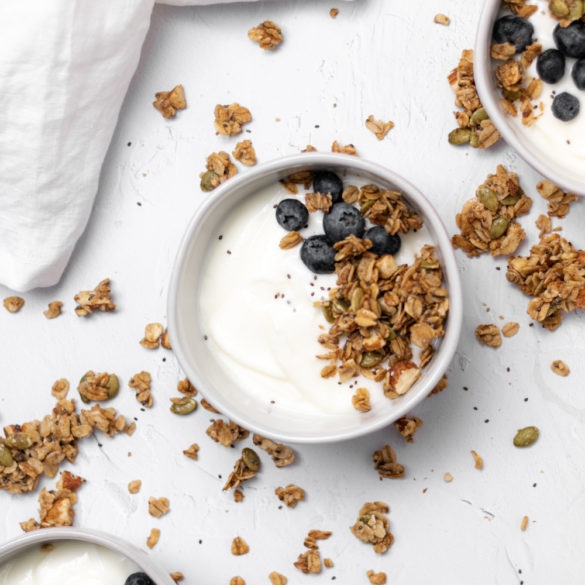 three bowls of yogurt topped with granola and blueberries